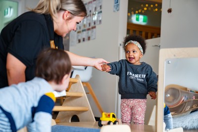 An educator holding a child's hand